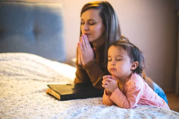 Mãe orando com uma criança